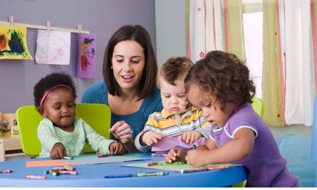 Adult with children at a table in nursery setting